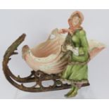 A late 19th century continental porcelain figure of a girl with shell shaped sleigh, blue crossed