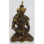 A contemporary bronze Tibetan double Buddha figure with gilt decoration and inlaid coloured