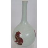 An antique Chinese porcelain bottle vase in white glaze bearing pink decoration of two temple