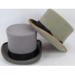 Two vintage grey felt top hats, each with black bands and piped brims. One by Wilson & Stafford (2).