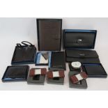 A selection of brand new leather luxury travel accessories, including four alarm clocks, passport