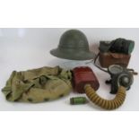 A WW2 military helmet, a 1940 military gas mask and bag, a WW2 civilian gas mask in box and carry