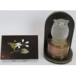 An antique hollow glass owl mounted on a brass strung ebony veneer bookend, possibly a car mascot,