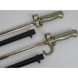 Two French model 1886/15 bayonets with scabbards with cruciform blades designed for Lebel rifles.