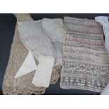 An unframed Georgian needlework sampler dated 1810, a 19th century Christening gown, a lace