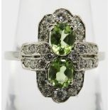 Platinum Victorian-style ring set with two oval-cut peridots and round brilliant cut diamonds,