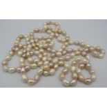 A freshwater pearl necklace, 60" long line continuous length, subtle shades of peach, pink &