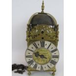 An Antique 17th century style brass lantern clock engraved 'Dadswell, Burwash', with later oak wall