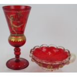 A ruby glass Venetian goblet decorated with nubile dancing figures over a gilded frieze. Triple knop