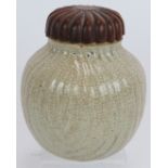 An unusual antique Chinese porcelain crackle glaze fluted jar with later carved wood cover, possibly