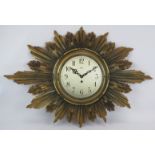 A 1930s carved wood gilt sunburst clock with Astral Coventry fusee movement and key. Width 92cm.