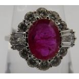 An 18ct white gold cluster ring set with an oval ruby surrounded by round brilliant cut diamonds,