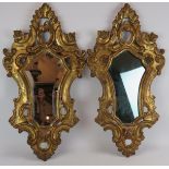 An ornate pair of early 20th century gilt wood Venetian style mirrors, one with bevelled glass.