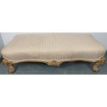 An antique beech shaped front low stool in the French taste, upholstered in gold and cream striped