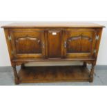 A reproduction medium oak two door side cabinet in the 18th century taste, on turned supports with