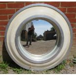 A large contemporary circular, convex wall mirror, in distressed cream and silver surround.