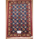 A small late 20th century Persian rug, repeat central pattern on blue field. 130cm x 74cm (