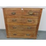 An Edwardian limed oak chest of two short over three long graduated drawers, with pressed brass