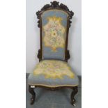 A Victorian show-wood high back tapestry seat nursing chair with ornately carved cornice, on
