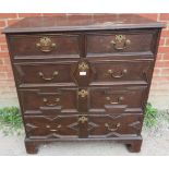 An antique oak chest in the Jacobean style, having two short over three long graduated drawers, with
