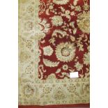 A part silk/wool carpet central flower pattern on claret ground and cream border. 112" x 76" (