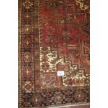 A super Heriz carpet, large central patterned field on claret ground and a deep border in brown.