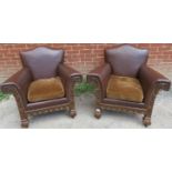 A pair of good turn of the century carved oak framed club armchairs, upholstered in brown leather