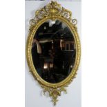 A very ornate 19th century gilt gesso oval wall mirror, with acanthus scrolled shell cornice.