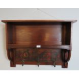 An Arts & Crafts mahogany wall hanging bookshelf with painted frieze under depicting a medieval