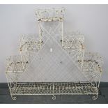 A vintage Regency style bent wire plant stand, with stepped sides and trough to base, on scrolled