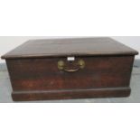 A small 19th century oak flat top trunk, with brad handles to front and sides, on a plinth base.