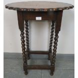 A vintage oak oval occasional table with piecrust edge, on barley twist supports with stretchers.