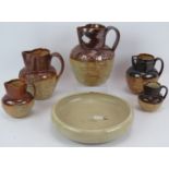 Five Stoneware harvest jugs of varying sizes, two marked Doulton and a Stoneware dish with sgraffito