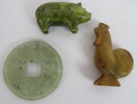 Three carved Chinese Jadeite hardstone objects including a rooster, a pig and an amulet coin.