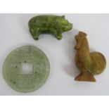 Three carved Chinese Jadeite hardstone objects including a rooster, a pig and an amulet coin.