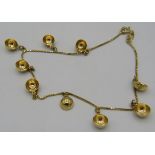 An 18ct yellow gold Omani ankle bracelet with 9 1/2 ball shaped hanging decorations, approx weight
