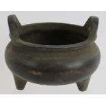 A Chinese bronze censer of squat form with tripod feet, raised handles and mark to base. Diameter