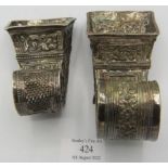 Two Far Eastern 19th century white metal cornucopian betel leaf containers, heavily embossed with