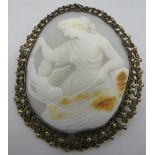 A large vintage cameo brooch in a filigree frame depicting a classical maiden tempting a cherub with