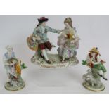 A Sitzendorf porcelain figure of a courting couple and two Sitzendorf figurines of country peasants.