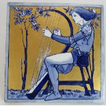 An antique Copeland Arts & Crafts tile depicting a harp player. Blue and white glaze with gilt
