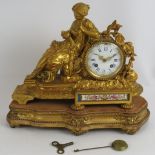 A 19th century ornate French gilt striking mantel clock with hand decorated porcelain panel, gilt