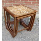 A set of three 1970s G Plan Astro nesting tables with tile insert to largest table, each on cross