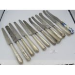 A collection of 11 various Georgian silver handled dinner knives and one china handled knife.