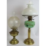 An early 20th century oil lamp with moulded green glass reservoir on a reeded brass column and