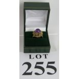 An attractive 1970s gold and amethyst dress ring with a central domed stone mounted in a