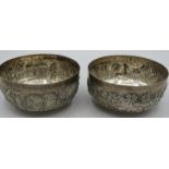 Two Indian white metal bowls with repousse relief scenes of village life & indigenous animals.