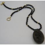 A bog oak pendant/locket with carved lily of the valley and on a bog oak necklace interspersed
