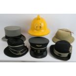 A 1970s Fireman's helmet, two vintage St John's Ambulance hats, a Swiss railways hat, grey top hat