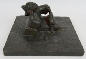 An antique Chinese bluestone carving of a reclining female with bound feet in the centre of a slab